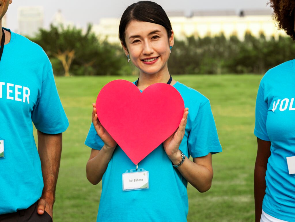 happy japanese volunteer with heart