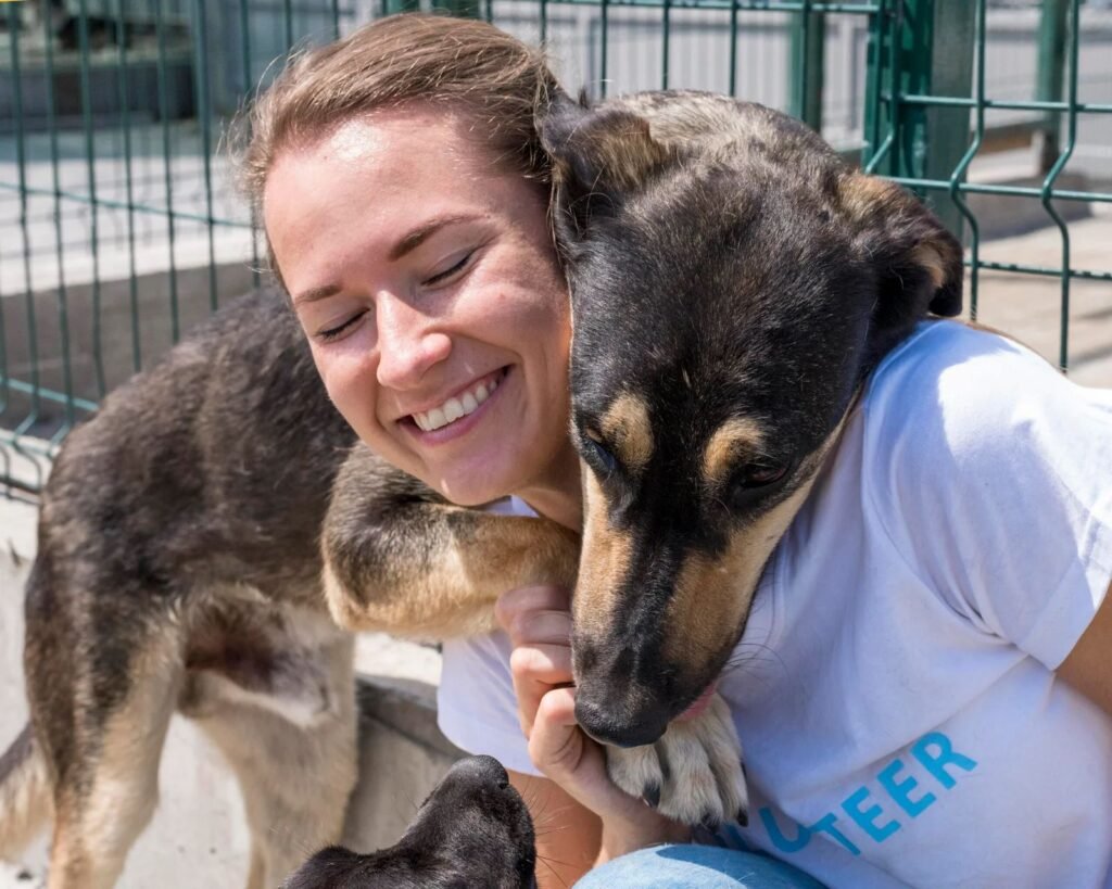 smiley woman playing with cute dog up adoption scaled 1