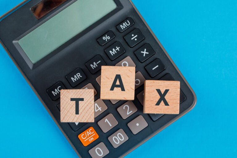 Tax Guidelines for Insurers Under New Reporting Rules 30 tax planning concept with wooden cubes calculator blue table flat lay
