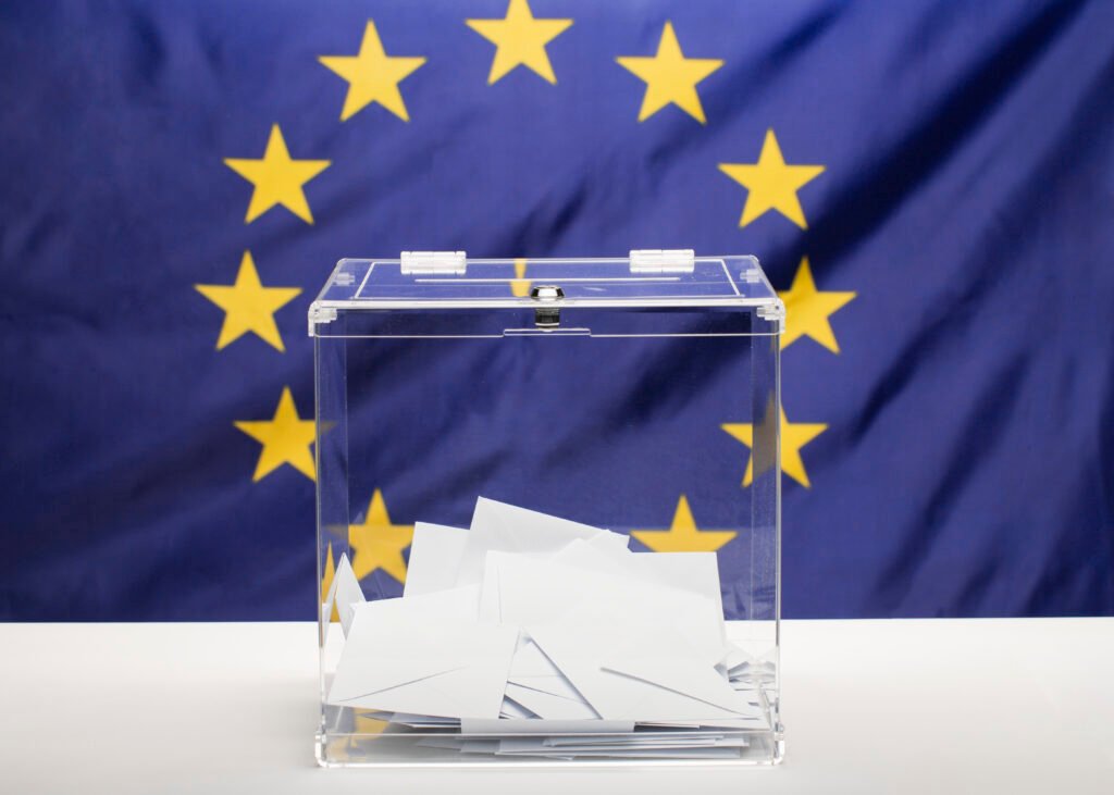 Droits de vote à Malte pour les expatriés 2 urne transparente remplie d'une enveloppe blanche drapeau de l'union européenne